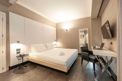 a bedroom with a bed and a desk with a laptop at Best Western Hotel Quattrotorri in Perugia