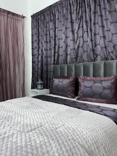a bedroom with a large white bed with purple pillows at Dar Ali - Guesthouse in Tozeur