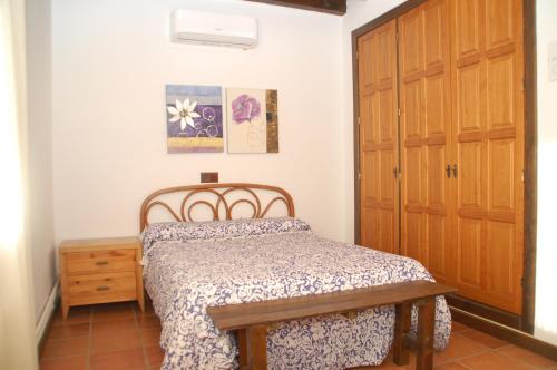 a bedroom with a bed and a wooden door at Casa rural Dalia in Sierra de Fuentes