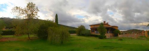 a house in a yard with a green field at Casa rural Dalia in Sierra de Fuentes
