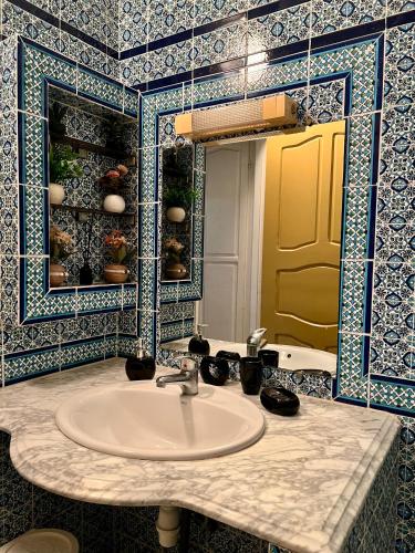 a bathroom with a sink and a mirror at Dar Ali - Guesthouse in Tozeur