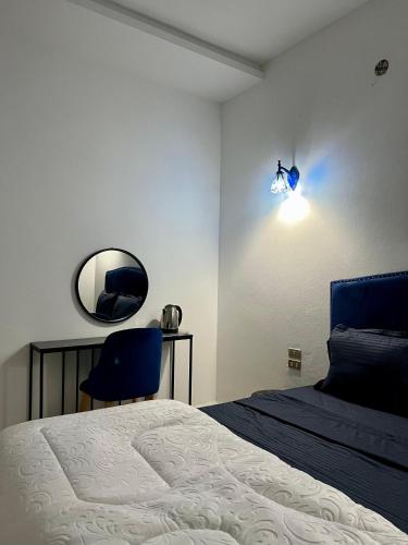 a bedroom with a bed and a mirror and a chair at Dar Ali - Guesthouse in Tozeur