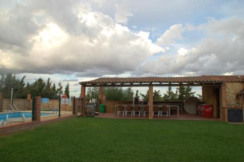 a backyard with a gazebo next to a pool at Casa rural Dalia in Sierra de Fuentes