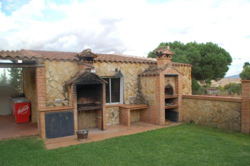 a house with a stone building with a patio at Casa rural Dalia in Sierra de Fuentes