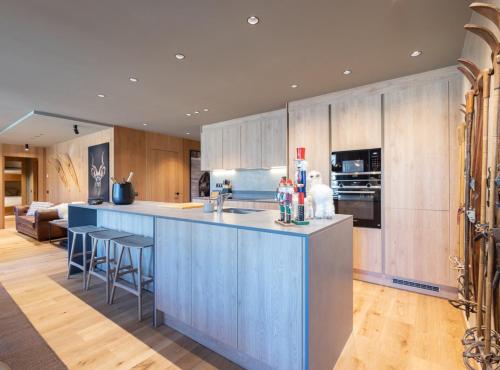 a kitchen with a blue island with bar stools at W Isard Lodge in El Tarter