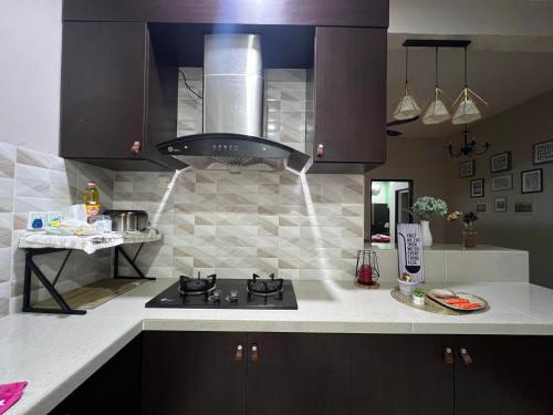 una cucina con piano cottura e forno di La Calma Private Pool a Jitra