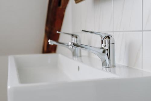 a bathroom sink with two faucets and a mirror at Seldas in Schaffhausen