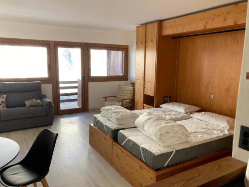 a bedroom with a large bed and a couch at Cielo Alto I Dadi in Breuil-Cervinia