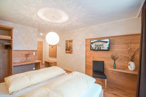 a bedroom with a bed and a desk and a chair at Breitenberger Hof "inklusive Frühstück" in Breitenberg