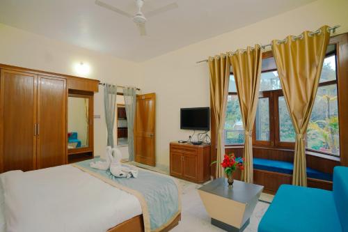 a bedroom with a bed and a tv and curtains at Chirping Hills Resort,Bhimtal in Bhīm Tāl