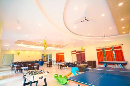 a room with a ping pong table and chairs at Chirping Hills Resort,Bhimtal in Bhīm Tāl