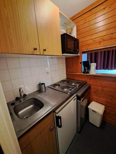 une petite cuisine avec un évier et une cuisinière dans l'établissement RPP C208 - Apt 3 pièces duplex 6 8 pers, à Tignes