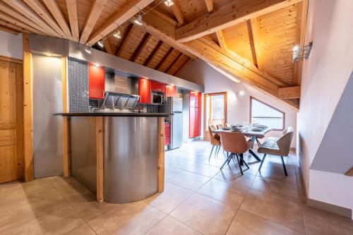 une cuisine et une salle à manger avec des armoires rouges et une table dans l'établissement Les croës, à Valloire
