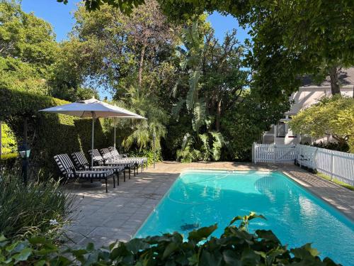 a swimming pool with chairs and an umbrella at The Prime Spot in Worcester