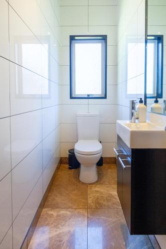 a bathroom with a toilet and a sink at Families and Groups, Chch Airport, Spa Pool in Christchurch