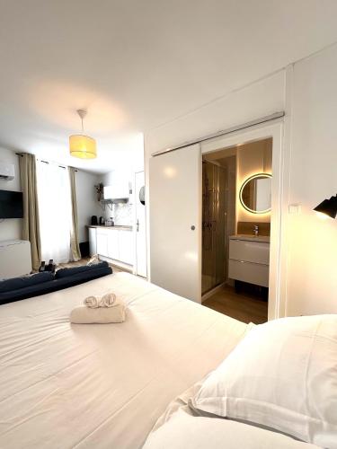a white bed with a white towel on top of it at Résidence La Ruelle Secrete - 5 studios - in Ruelle-sur-Touvre