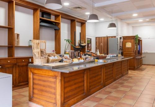 a large kitchen with wooden cabinets and a counter top at B&B HOTEL Amiens Centre Cathédrale in Amiens