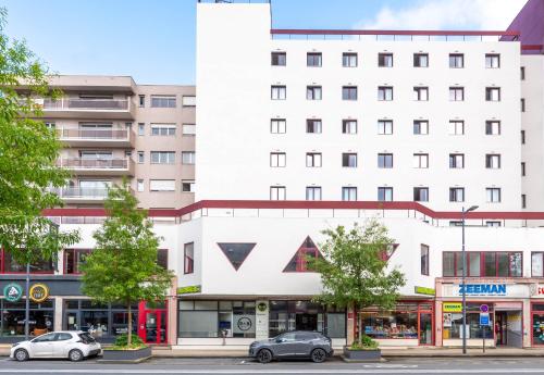 a white building with cars parked in front of it at B&B HOTEL Amiens Centre Cathédrale in Amiens