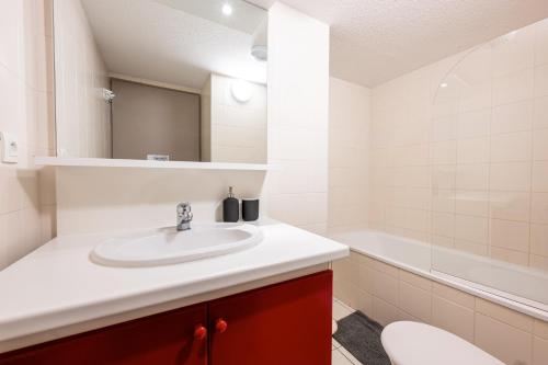 un bagno con lavandino, WC e vasca di Valloire - Appartement avec piscine a Valloire
