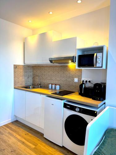 a kitchen with white cabinets and a sink and a stove at Résidence La Ruelle Secrete - 5 studios - in Ruelle-sur-Touvre