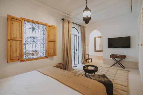 une chambre avec un lit et une télévision à écran plat dans l'établissement Riad Babel au coeur de la Médina, à Marrakech
