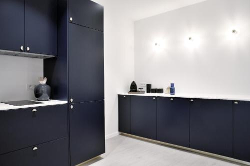 a room with black cabinets and a white wall at Urban Walls in Brussels