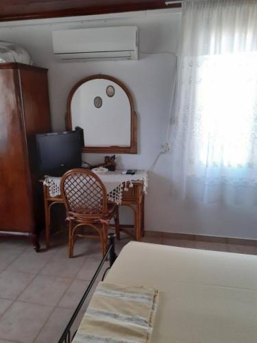 a room with a table and a television and a mirror at Maria's Home in Kakóvatos