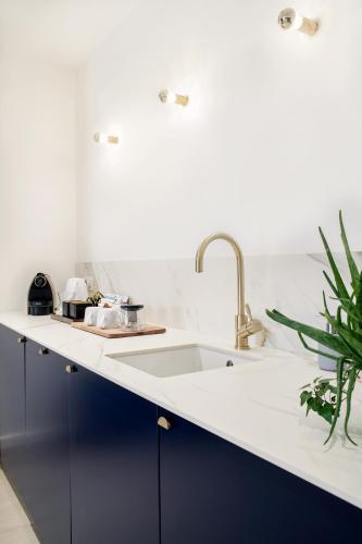 a kitchen with blue cabinets and a sink at Urban Walls in Brussels