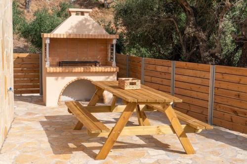 a picnic table with a pizza oven on a patio at Tzortzatos Tiny Home in Kouroukláta
