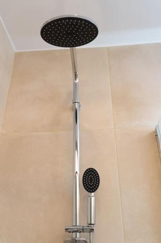 a shower head in a bathroom with a ceiling at Tzortzatos Tiny Home in Kouroukláta