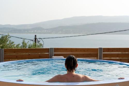a person in a jacuzzi in a swimming pool at Tzortzatos Tiny Home in Kouroukláta