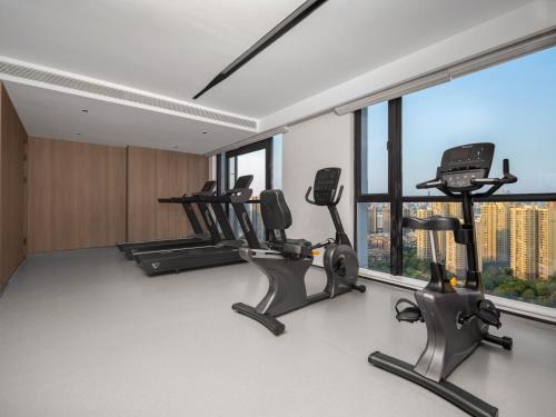 a gym with treadmills and ellipticals in a room with windows at Holiday Inn & Suites Chongqing Nanan by IHG in Chongqing
