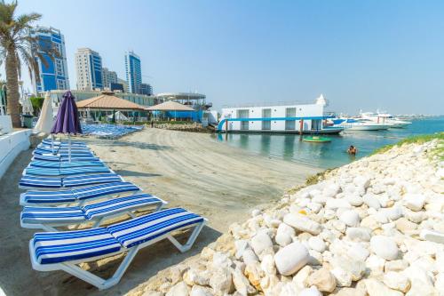- une rangée de chaises longues assises sur une plage dans l'établissement C Hotel, à Manama