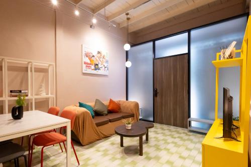 a living room with a couch and a tv at Siam Twin Charoenkrung in Bangkok