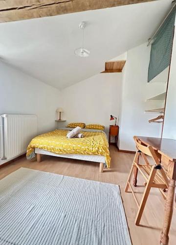 une chambre avec un lit avec une couverture jaune dans l'établissement Les Rincinières, à La Garnache