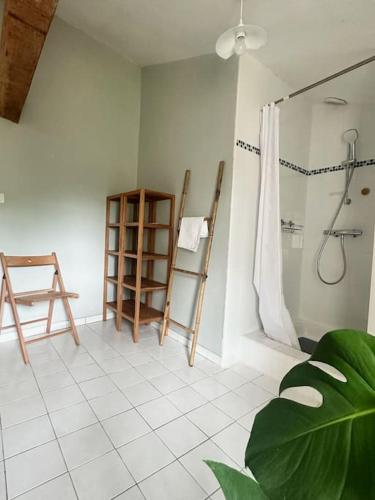 La salle de bains est pourvue d'une douche et de carrelage blanc. dans l'établissement Les Rincinières, à La Garnache
