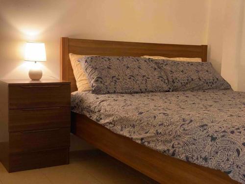 罗金汉姆Cosy, private guest house with pool and private parking的一间卧室配有一张床和一个带灯的床头柜