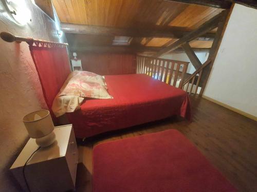 - une chambre mansardée avec un lit rouge dans l'établissement maison de village, à Vendres