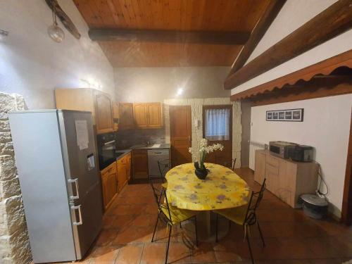 une cuisine avec une table et un chiffon de table jaune dans l'établissement maison de village, à Vendres