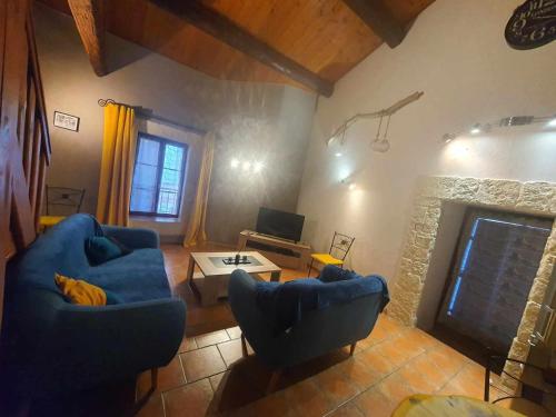 - un salon avec deux chaises bleues et une cheminée dans l'établissement maison de village, à Vendres