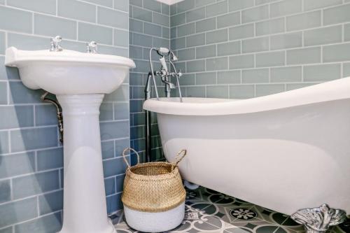 a bathroom with a sink and a toilet and a tub at Stunning Maida Vale Apartment in London