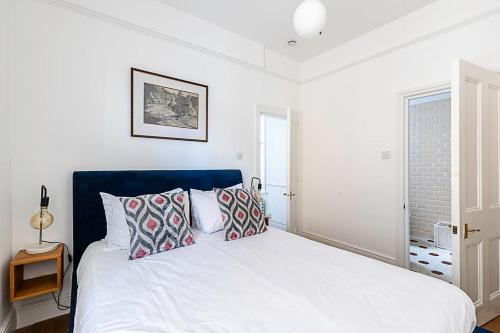 a bedroom with a large white bed with pillows at Stunning Maida Vale Apartment in London