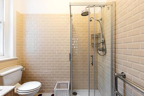a bathroom with a toilet and a glass shower at Stunning Maida Vale Apartment in London