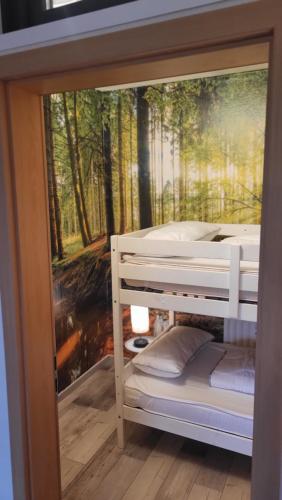 a wall mural of a forest with bunk beds at Modernisierte Ferienwohnung Naturseelen mit Schwimmbad und Sauna in Braunlage