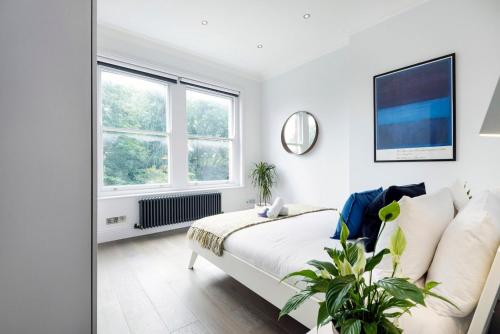 Una habitación blanca con una cama y una ventana en Modern and Bright Highgate Gem, en Londres