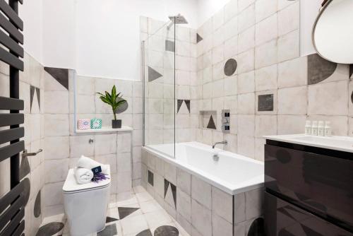 a bathroom with a tub and a toilet and a sink at Modern and Bright Highgate Gem in London