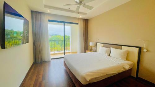 a bedroom with a bed and a large window at Vinholidays Fiesta Phu Quoc in Phu Quoc