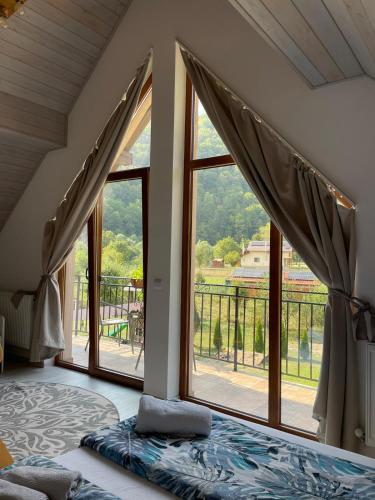 a bedroom with a bed and a large window at cabana din padure in Finiş
