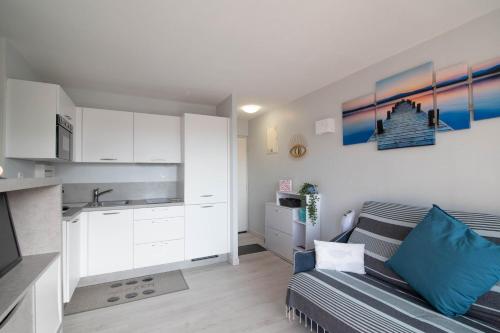 un salon avec un canapé et une cuisine dans l'établissement appartement bord de mer, à Saint Cyprien Plage