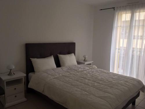 une chambre avec un grand lit et une fenêtre dans l'établissement Appartement centre plage à pieds, à Arcachon